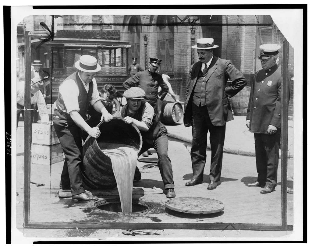 New York City Deputy Police Commissioner John A. Leach, right, watching  agents pour liquor into sewer following a raid during the height of  prohibition] - PICRYL - Public Domain Media Search Engine